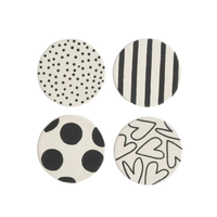 Four round coasters with black and white patterns on a white background