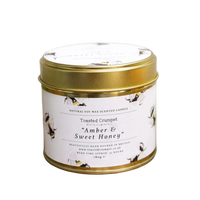Scented candle in a tin with a gold lid on a white background