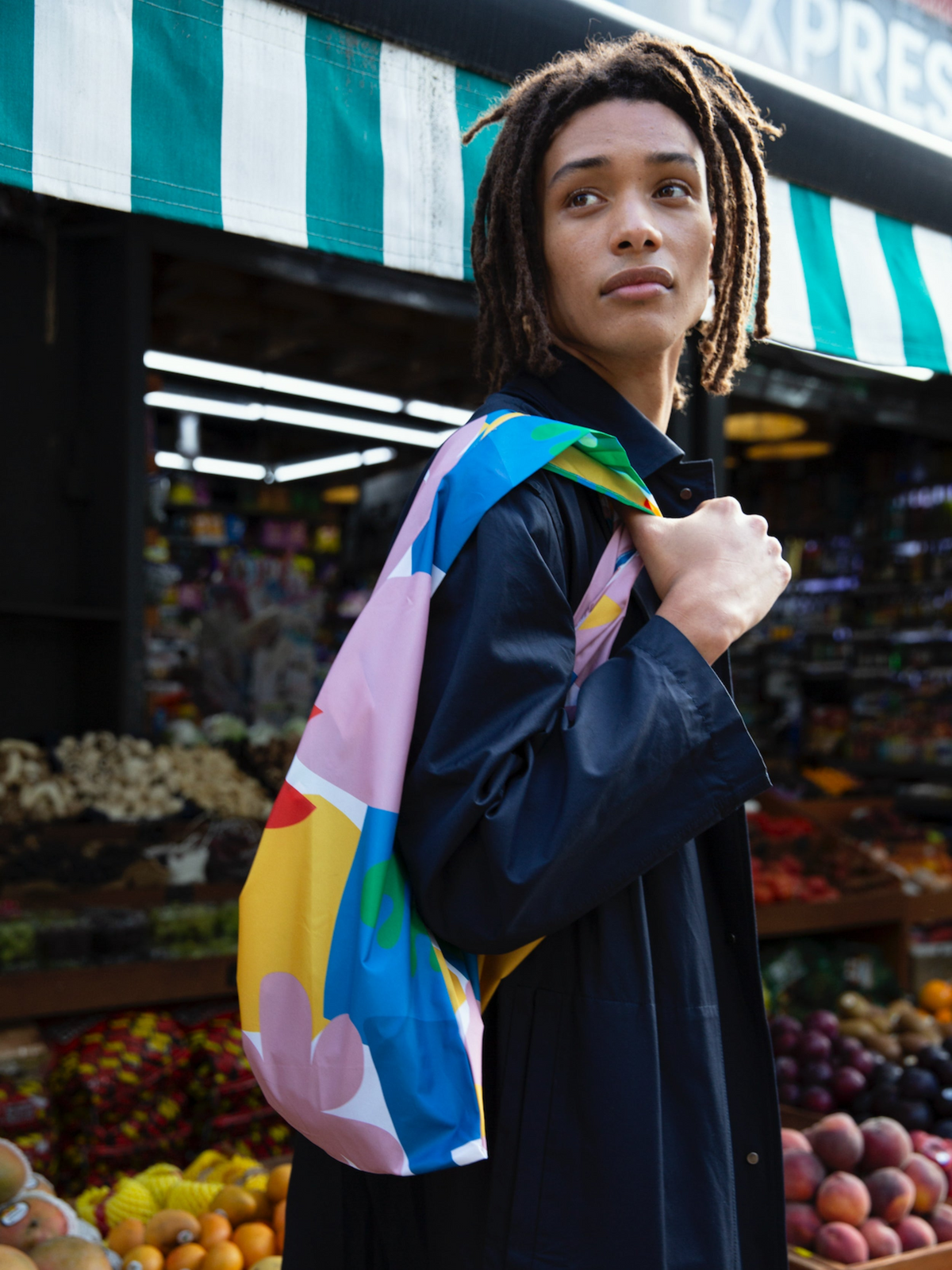 Person holding a colorful bag in a market setting